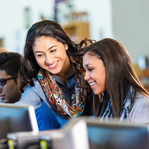 Teacher helping Student at computer